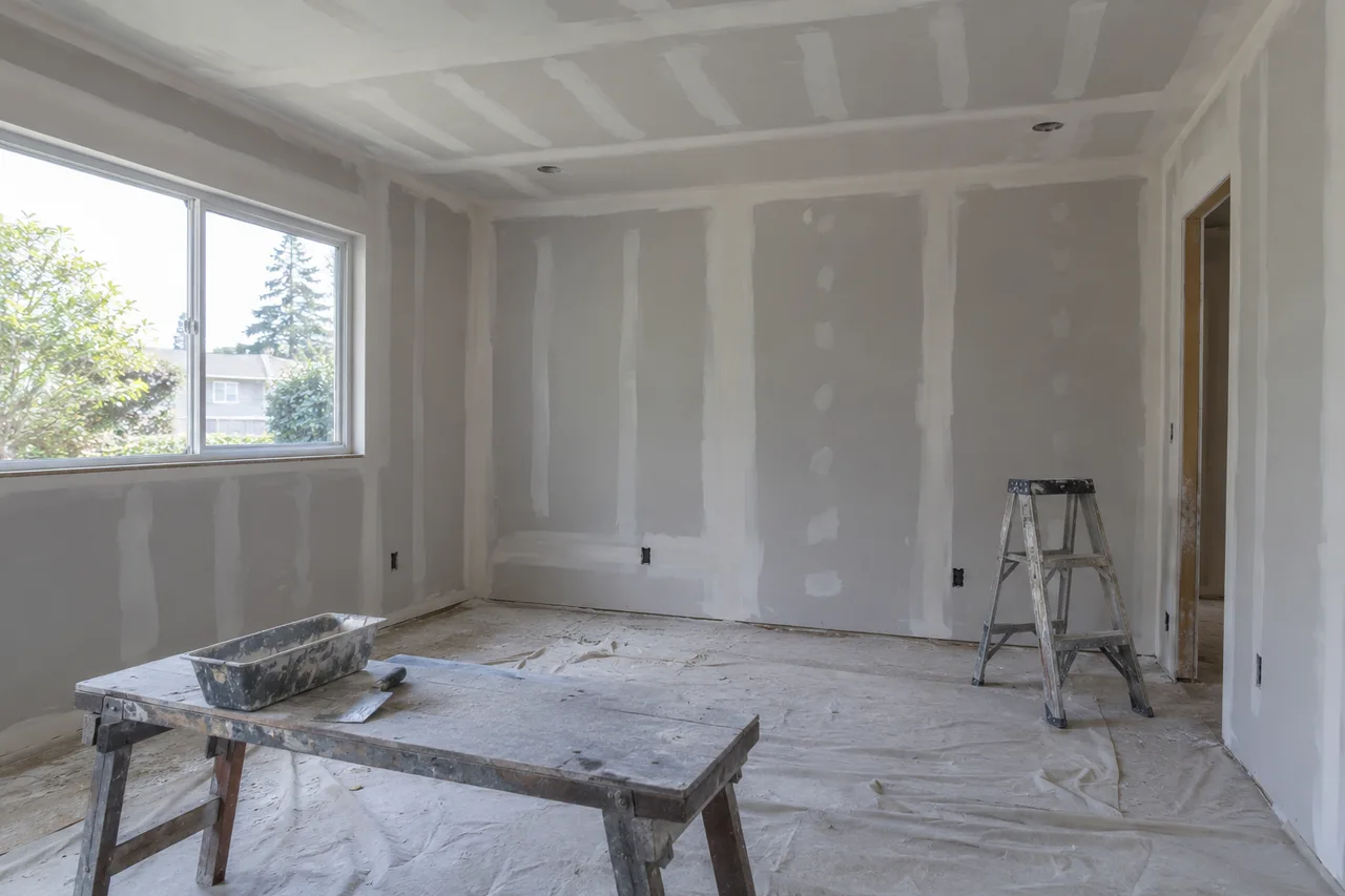 Unpainted drywall with compound along wall and ceiling joints and fasteners.